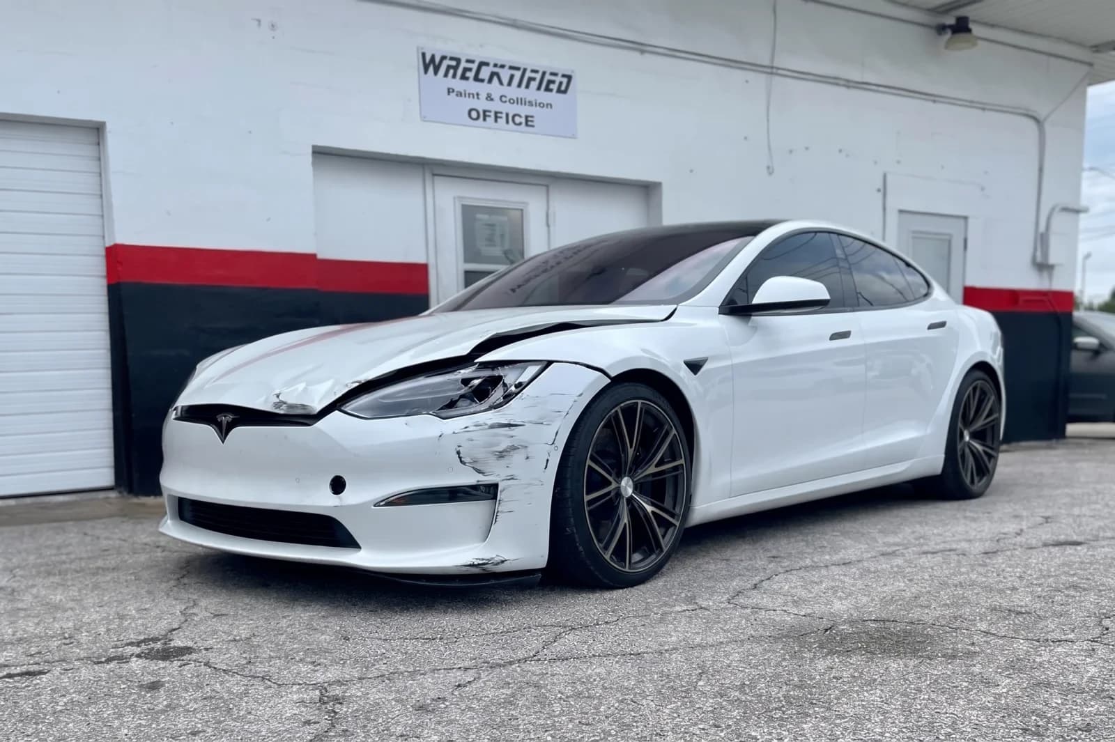 The same white Tesla Model S with front-end collision damage before repair