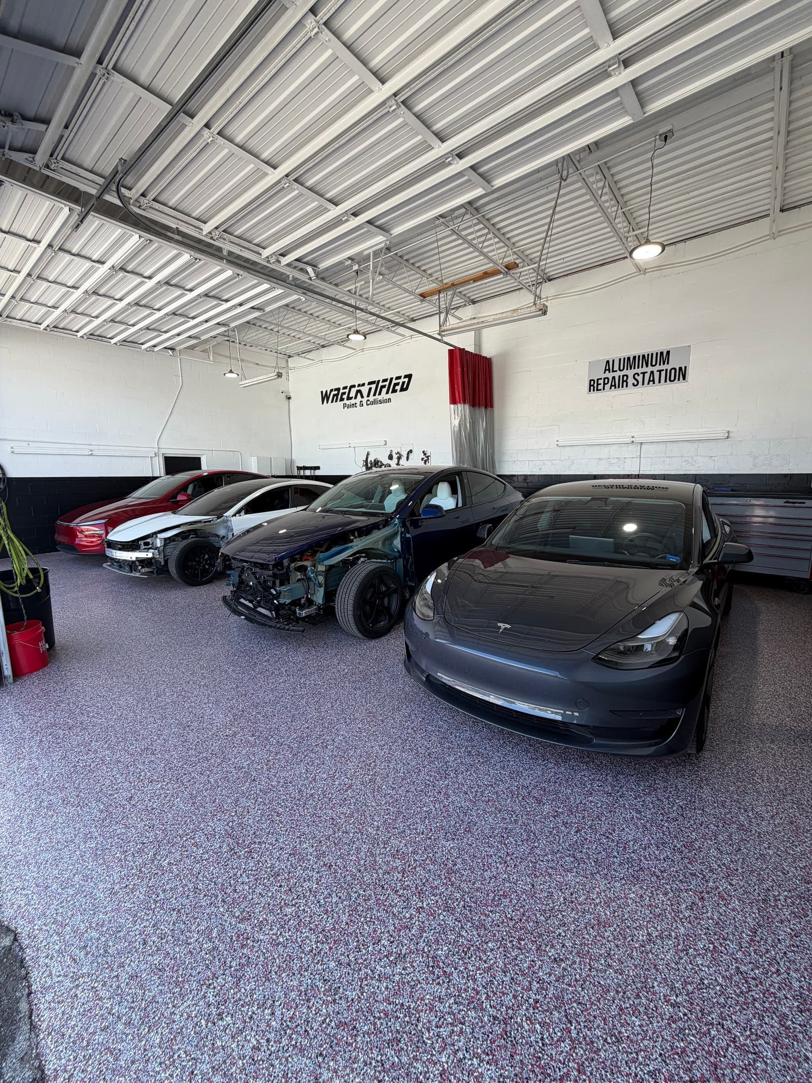 Teslas lined up in the aluminum repair station at Wrecktified Paint & Collision in Clearwater, FL